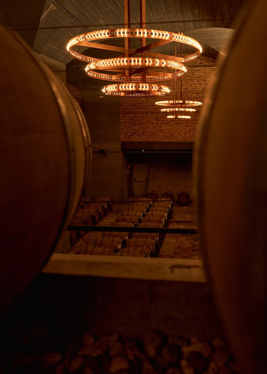 The copper chandelier cellar seen through the oak foudres.