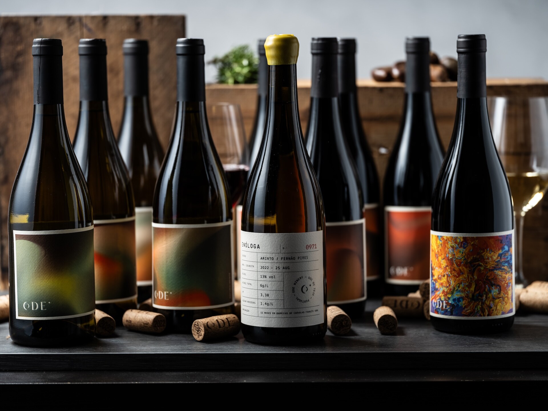 ODE wine bottles on a dark studio surface.